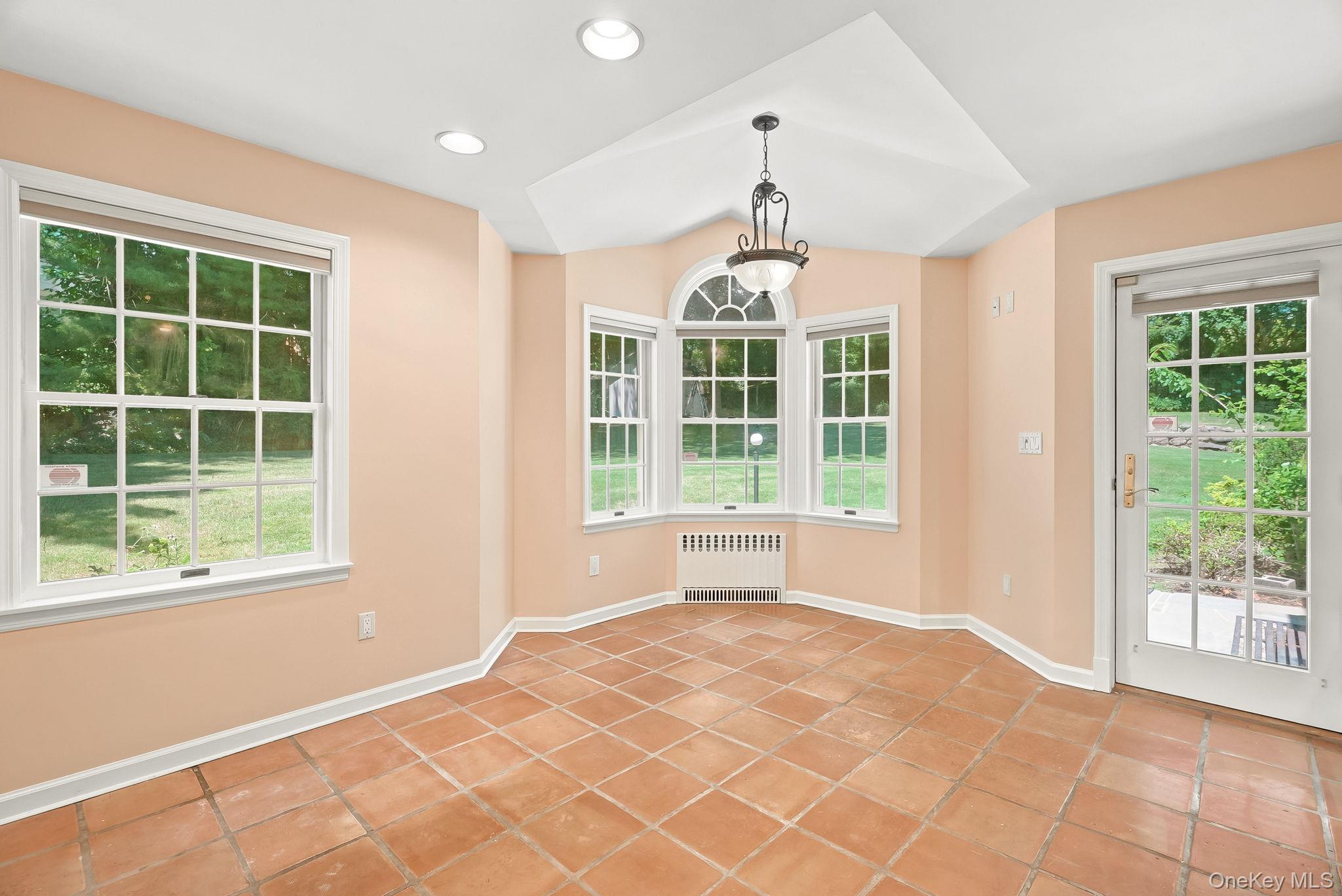 1 Sheridan Road Scarsdale, NY 10583 - Photo 15 of 40 Diagonal view of Great Room showing bow window designed to accomodate in- kitchen dining and door to patio for alfresco meals
