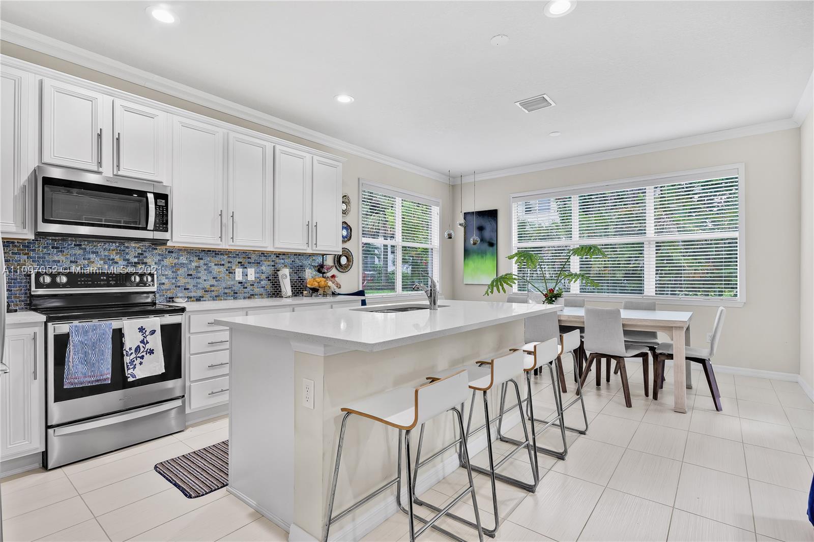 4325 Large Leaf Lane Hollywood, FL 33021 - Photo 22 of 42 a kitchen with stainless steel appliances granite countertop a stove a sink a microwave and a dining table