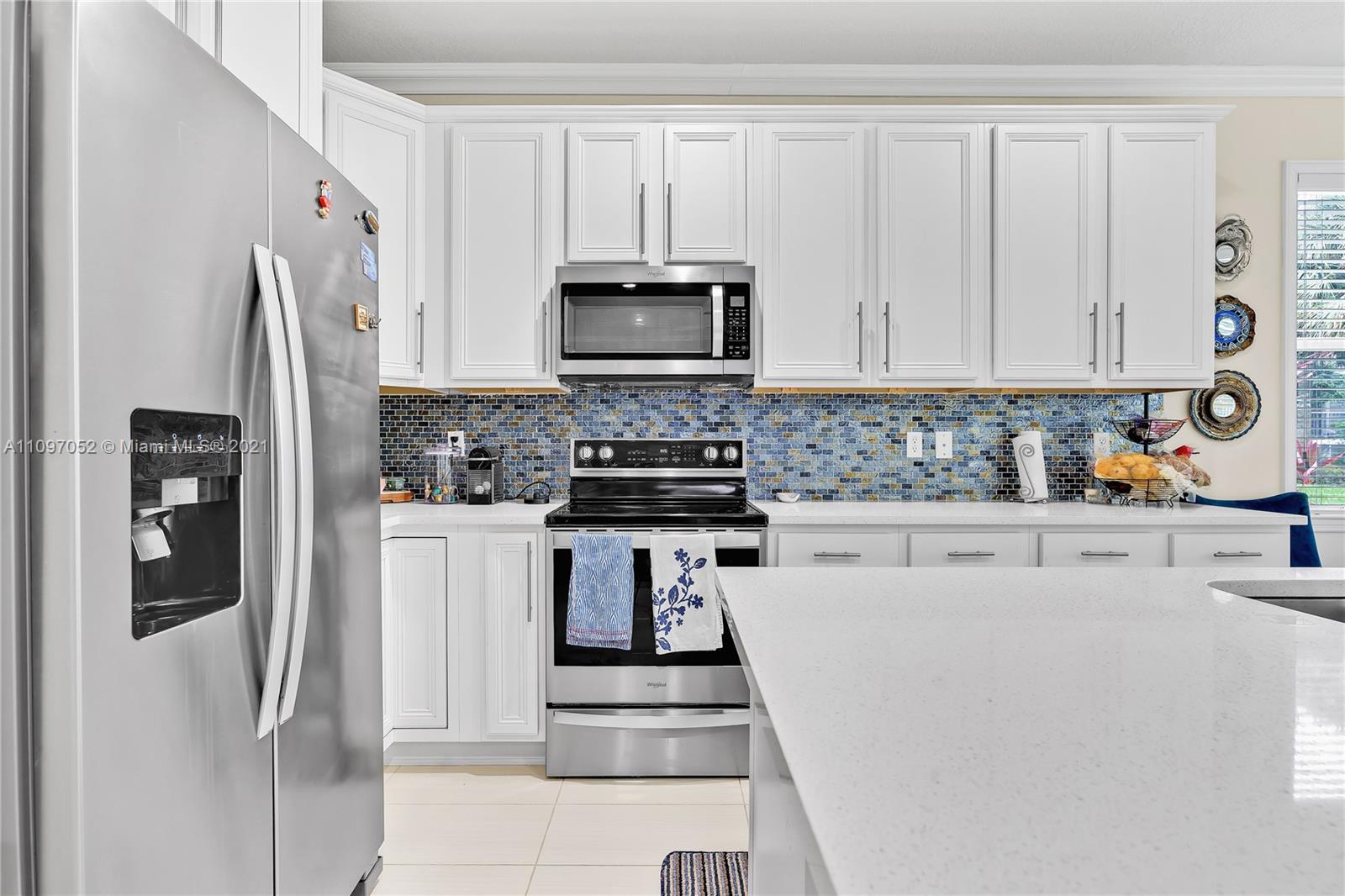 4325 Large Leaf Lane Hollywood, FL 33021 - Photo 23 of 42 a kitchen with white cabinets and stainless steel appliances