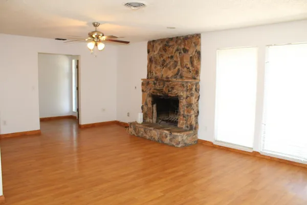 a view of an empty room with closet and wooden floor