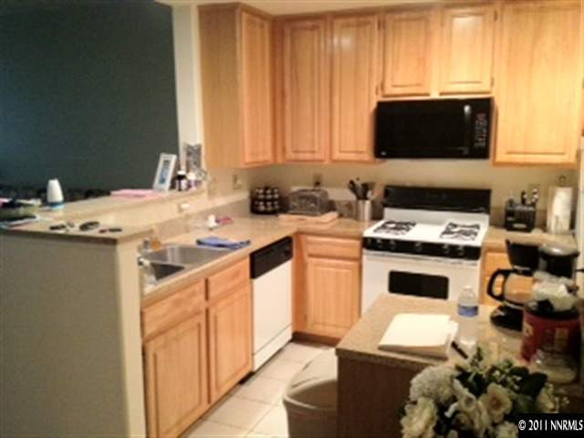 900 S Meadows, Unit 5213 Reno, NV 89521 - Photo 1 of 1 a kitchen with a stove a sink and a microwave