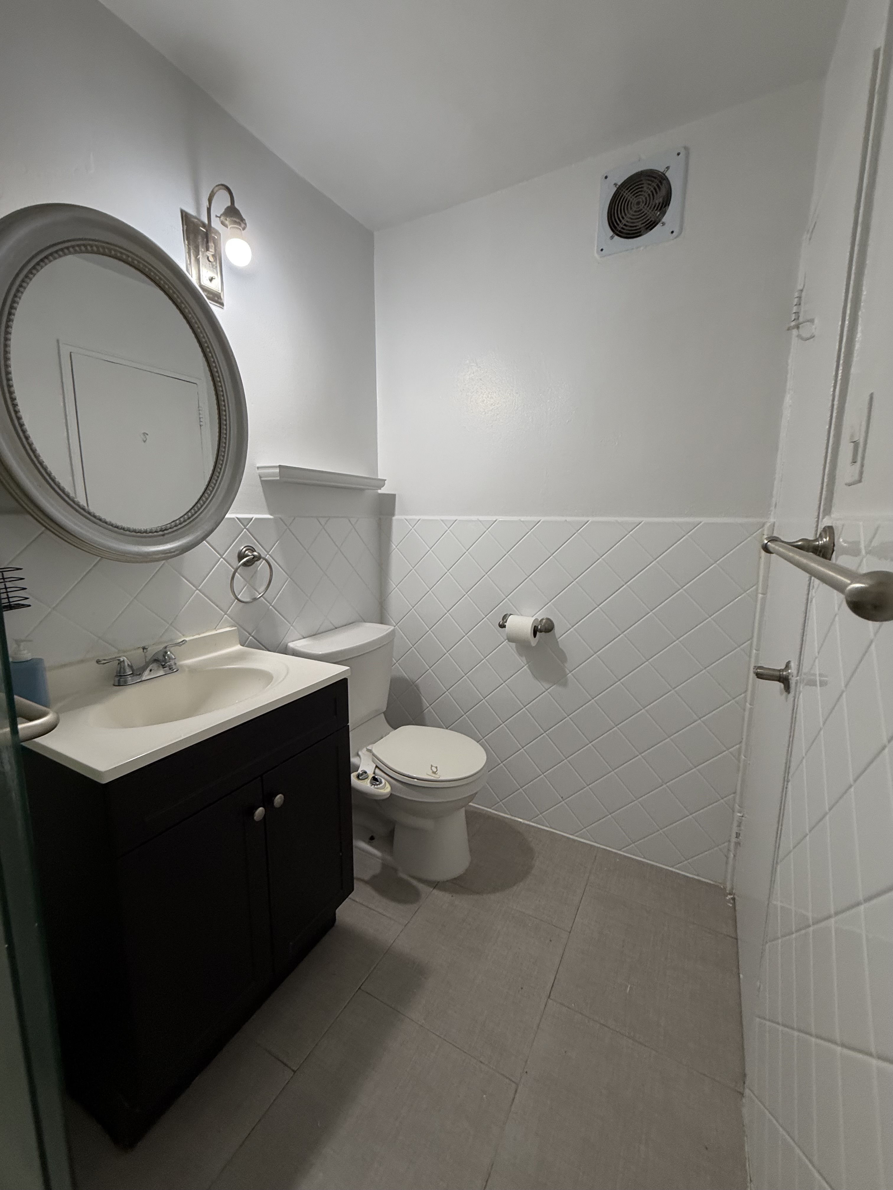 85-15 Main Street, Unit 2R Queens, NY 11435 - Photo 4 of 15 a bathroom with a toilet sink vanity granite and a mirror