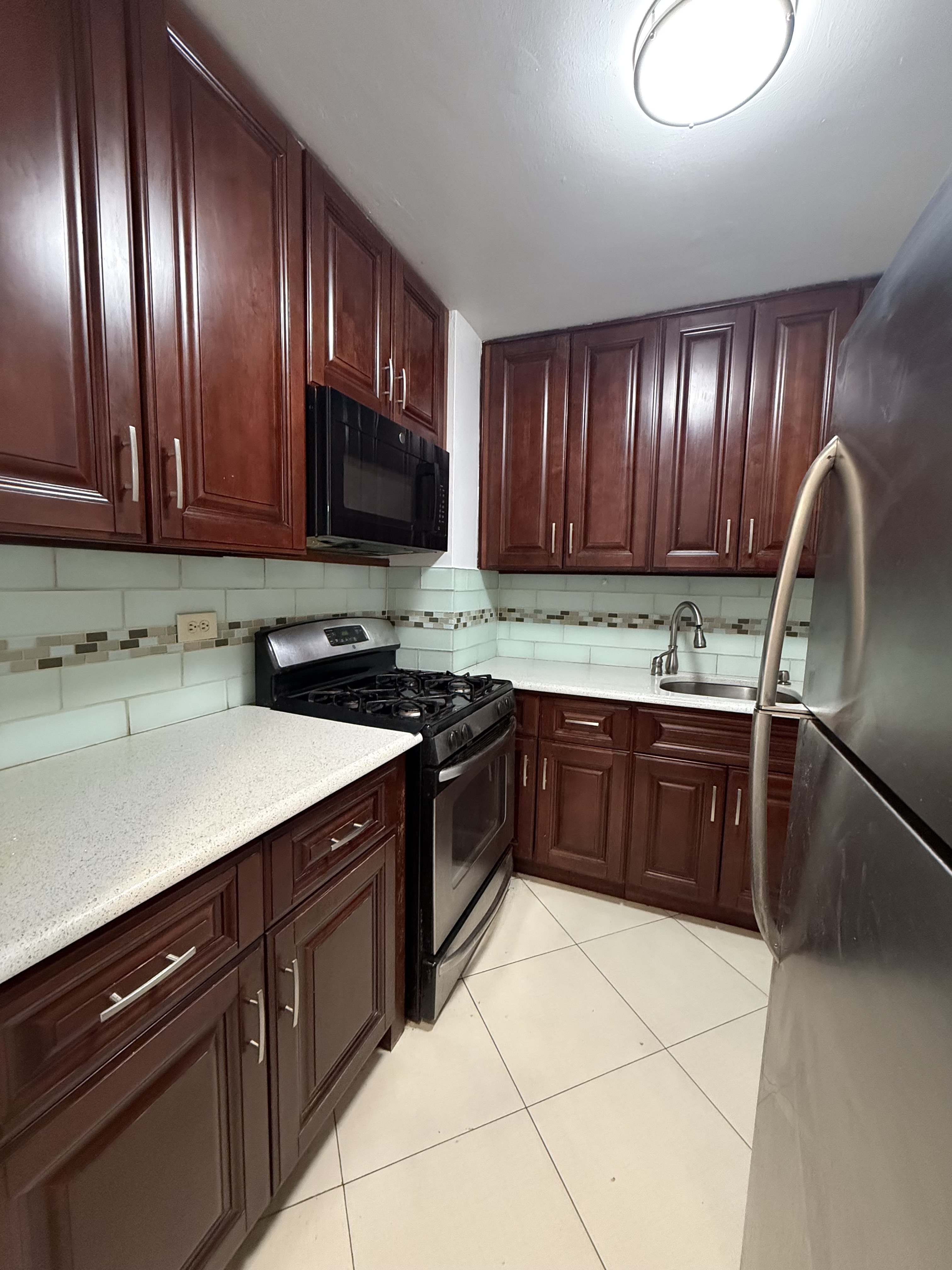 85-15 Main Street, Unit 2R Queens, NY 11435 - Photo 6 of 15 a kitchen with a sink and a stove top oven