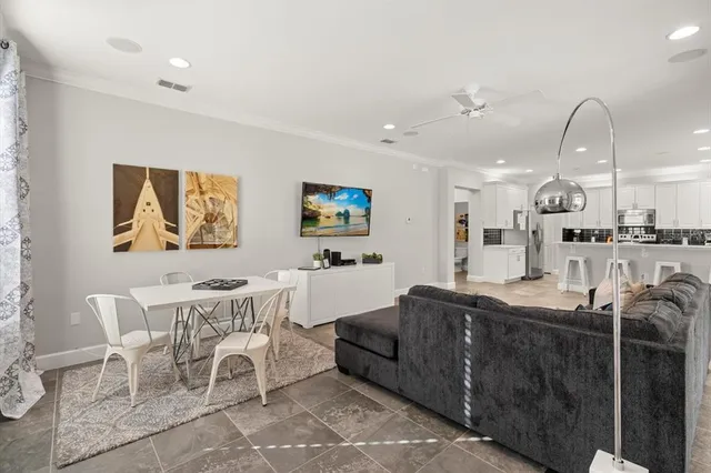 a living room with furniture a refrigerator and kitchen view