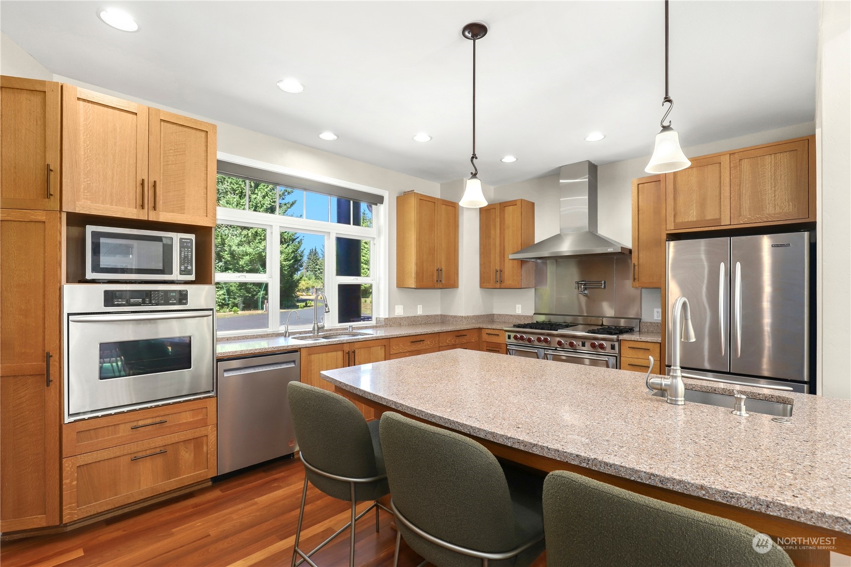 9109 Rich Road Southeast Olympia, WA 98501 - Photo 10 of 40 a kitchen with stainless steel appliances granite countertop a stove a sink a refrigerator a center island a stove and a refrigerator with wooden floor