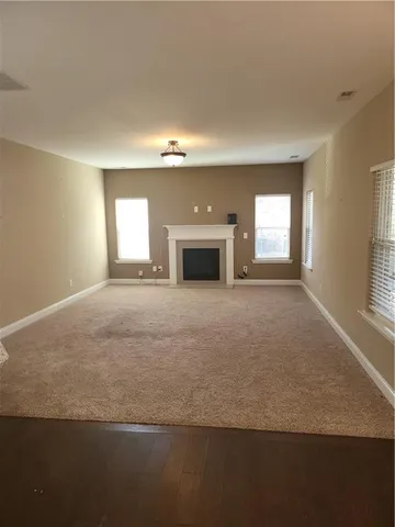 a view of an empty room with a fireplace and a window