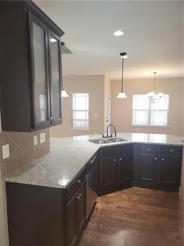 a kitchen with a sink a counter space and wooden floor