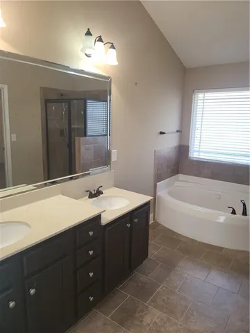 a bathroom with a tub a sink and mirror