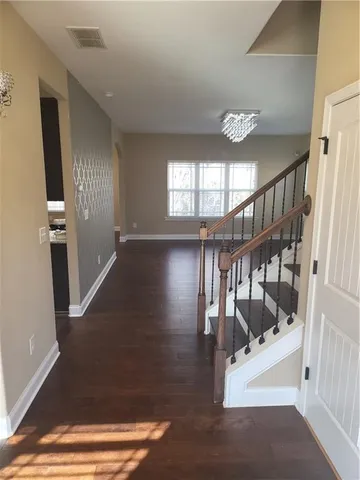 a view of entryway and hall with wooden floor