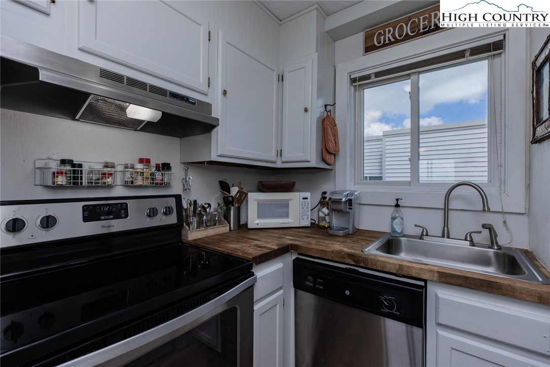 301 Pinnacle Inn Road, Unit 4305 Beech Mountain, NC 28604 - Photo 11 of 49 a kitchen with stainless steel appliances a stove a sink and cabinets