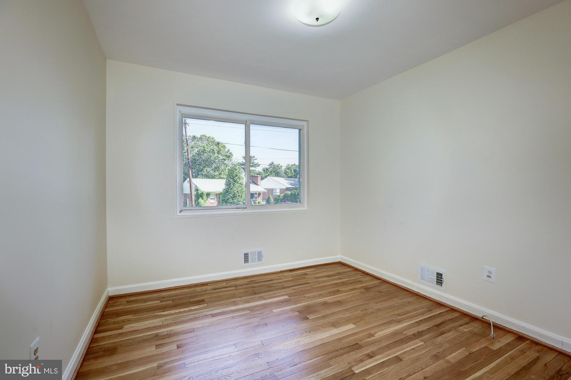 10123 Renfrew Road Silver Spring, MD 20901 - Photo 9 of 18 an empty room with wooden floor and window