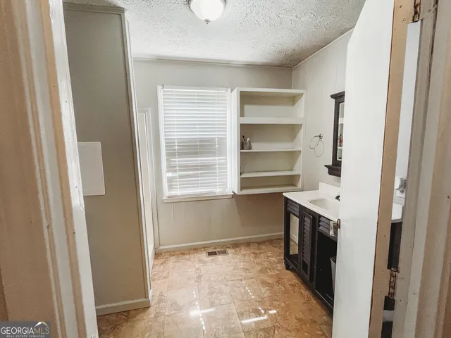 a kitchen with granite countertop a refrigerator and a stove top oven