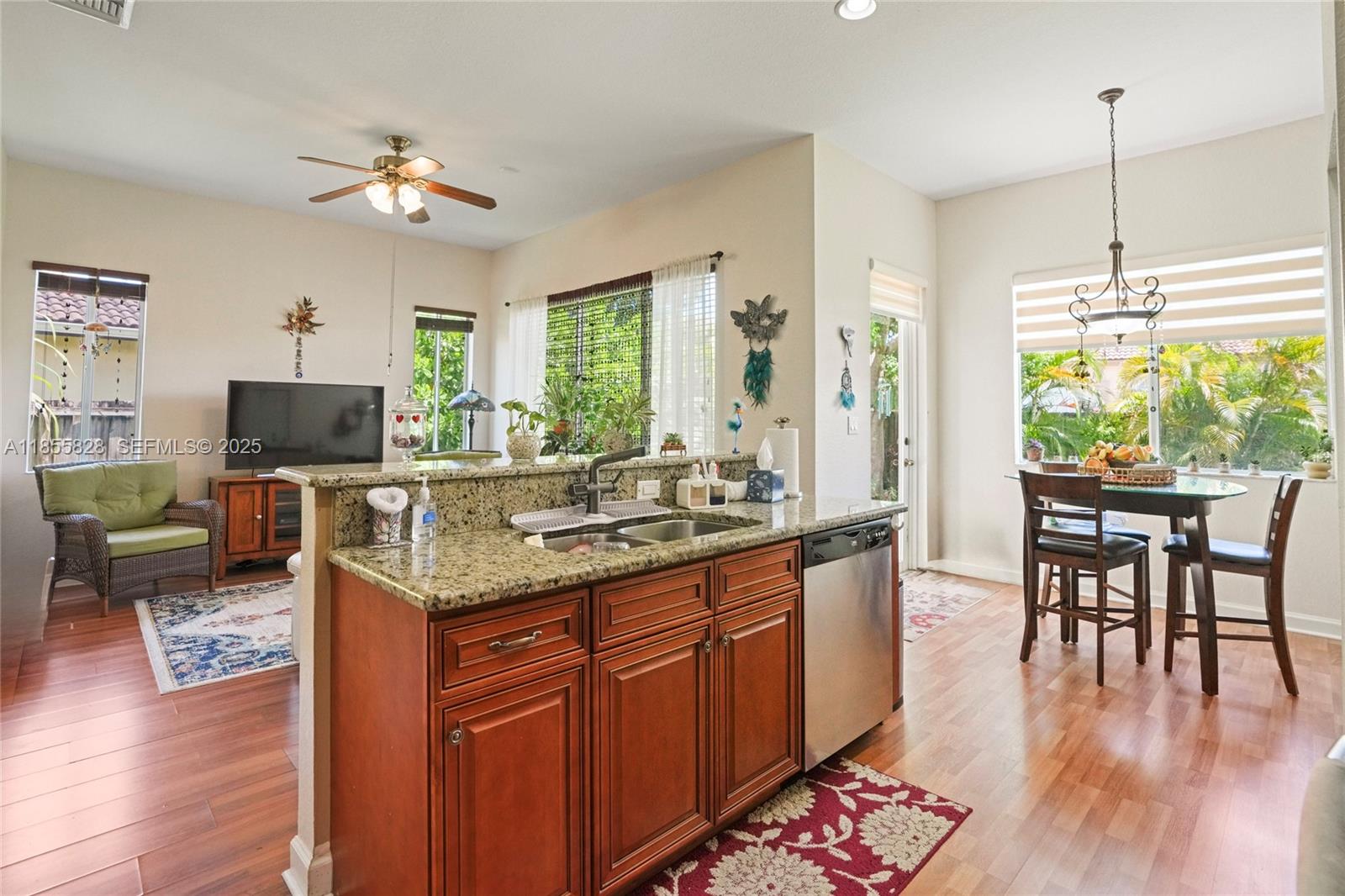 9506 Southwest 220th Lane Cutler Bay, FL 33190 - Photo 12 of 51 a kitchen with stainless steel appliances granite countertop a stove oven a dining table and chairs with wooden floor