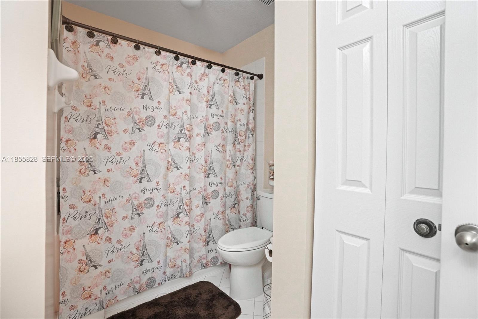 9506 Southwest 220th Lane Cutler Bay, FL 33190 - Photo 24 of 51 a bathroom with a toilet and a shower curtain
