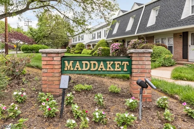 a view of a brick house with a yard and plants