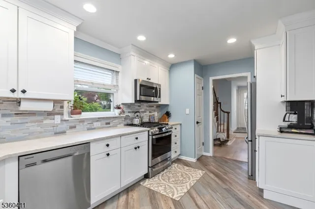 a kitchen with a sink a window a refrigerator and stainless steel appliances