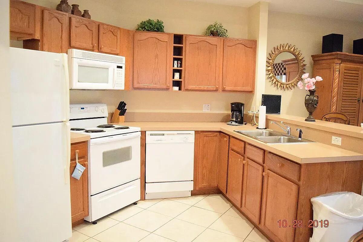 8356 Mulligan Circle, Unit 1924A Port St. Lucie, FL 34986 - Photo 9 of 15 a kitchen with a sink cabinets and appliances