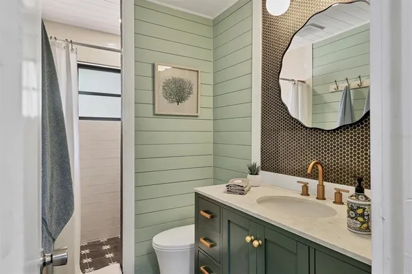 a bathroom with a sink vanity mirror and toilet