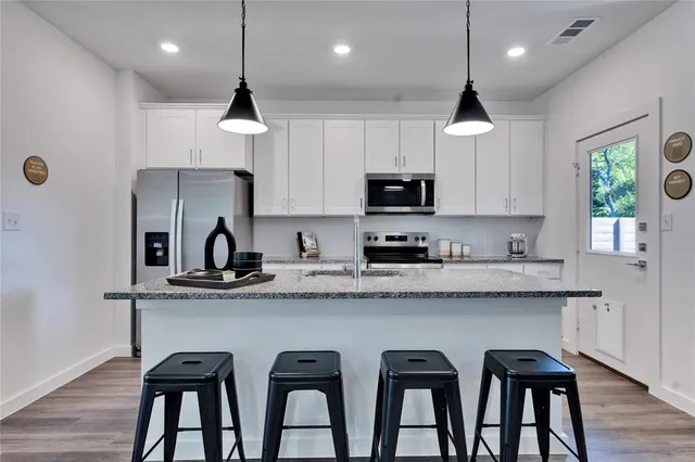 a kitchen with sink refrigerator and microwave