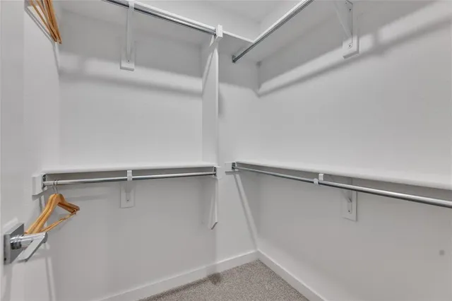 a view of a livingroom with the kitchen and a window