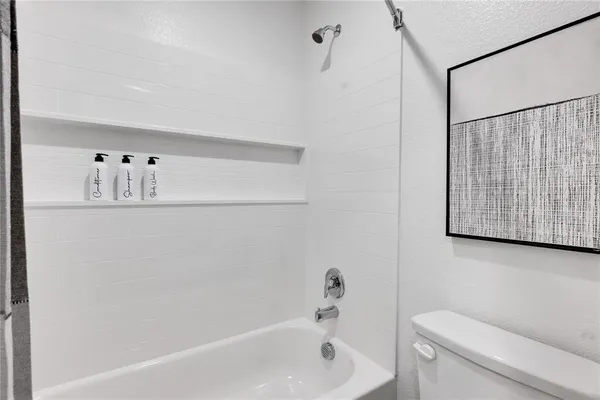 a hallway with white cabinets and wooden floor
