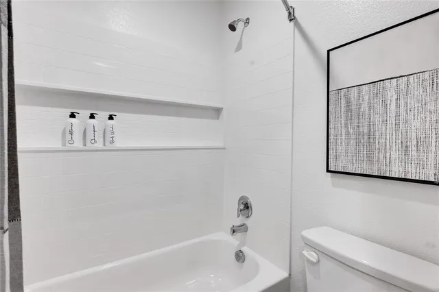 a hallway with white cabinets and wooden floor