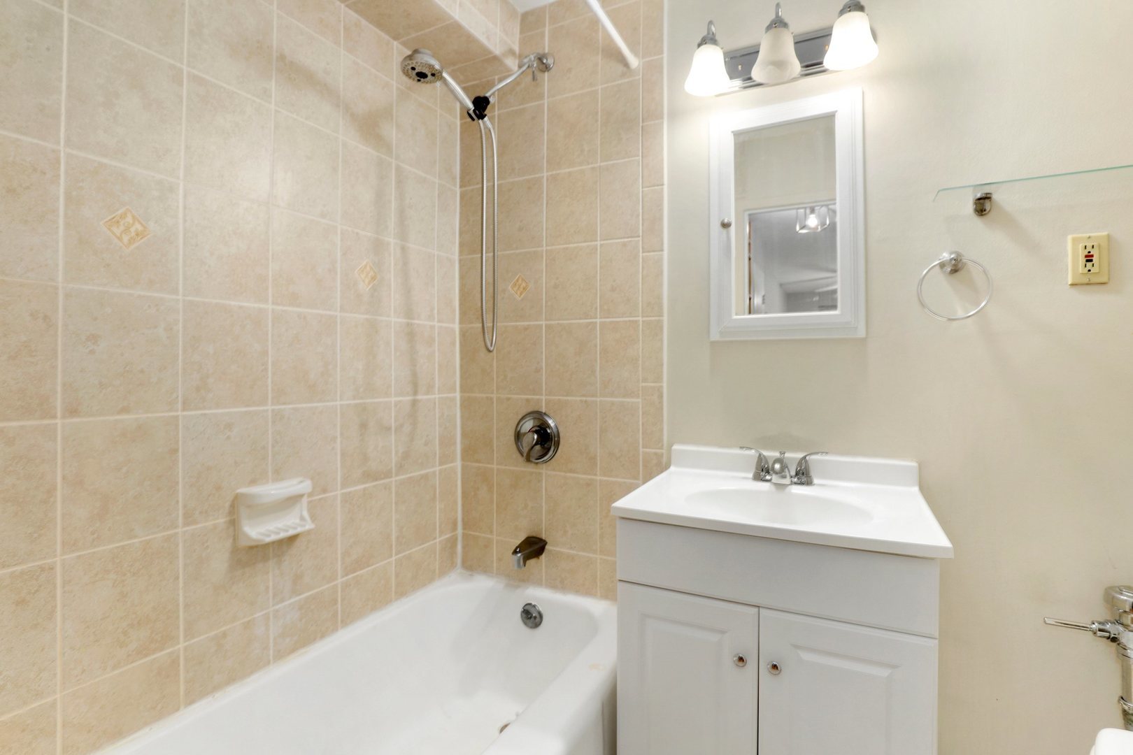 Undisclosed Address Chicago, IL 60657 - Photo 13 of 18 a bathroom with a sink a shower and a mirror