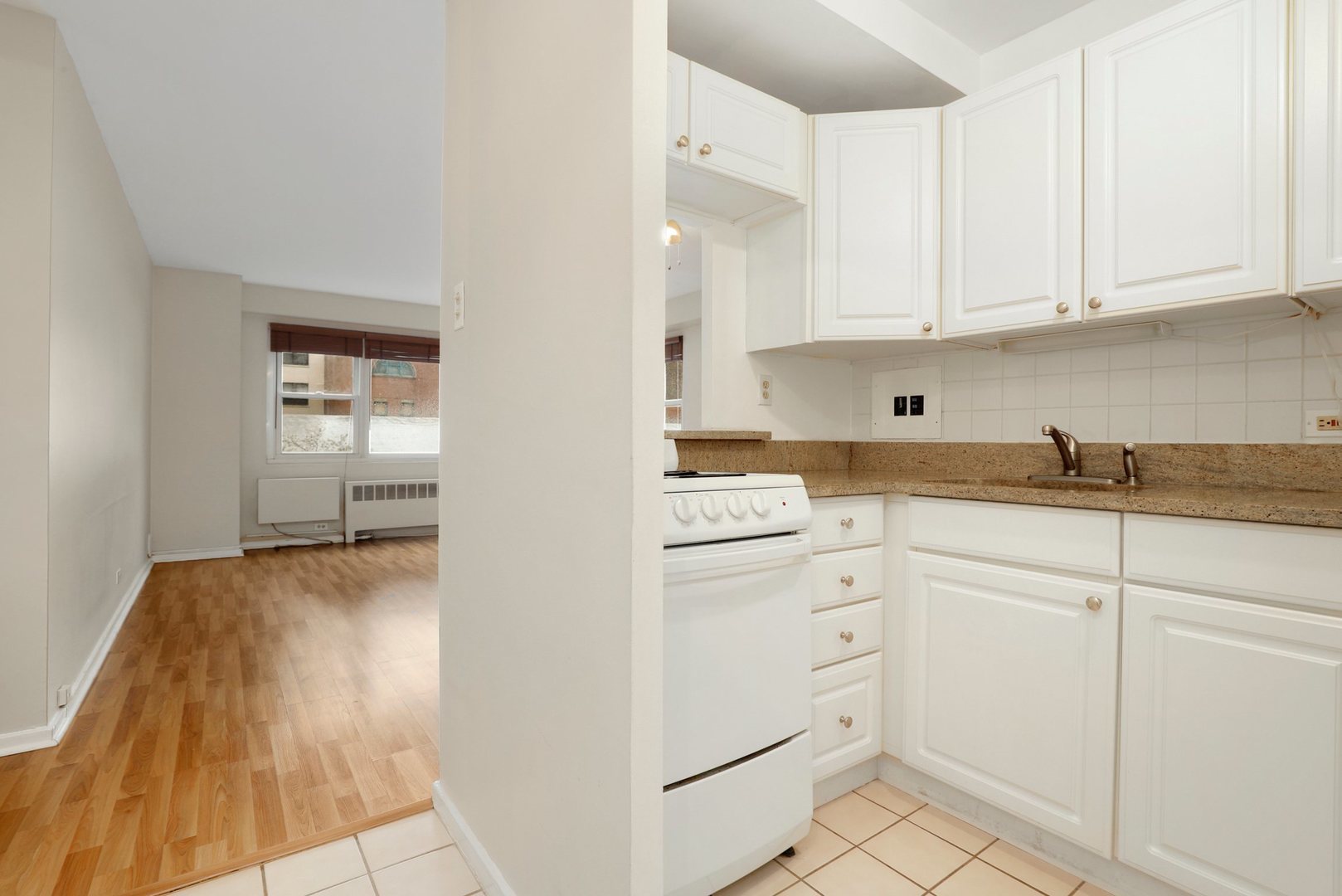 Undisclosed Address Chicago, IL 60657 - Photo 2 of 18 a kitchen with white cabinets and white appliances