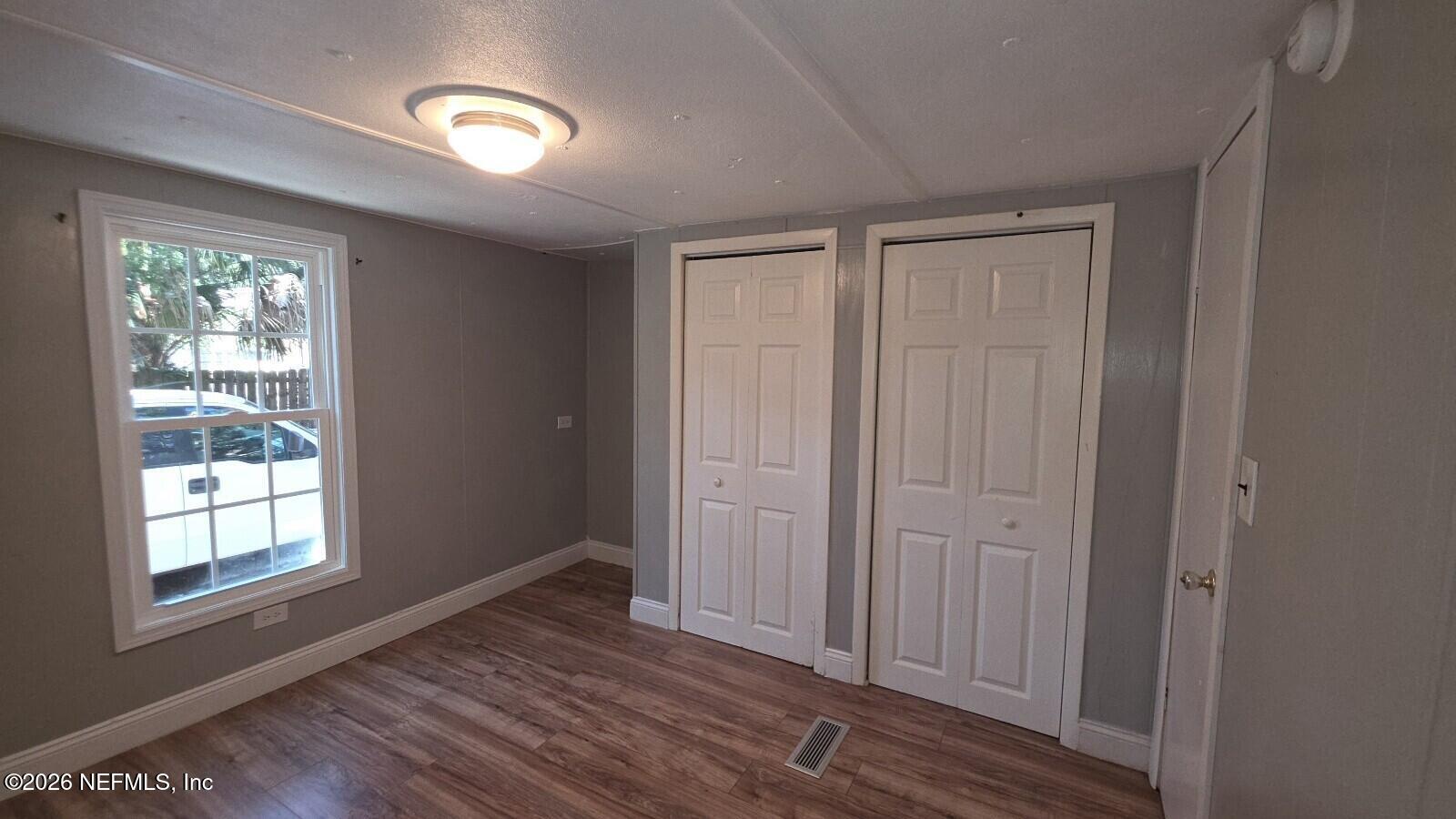 2781 Schaller Road St. Augustine, FL 32084 - Photo 5 of 9 an empty room with wooden floor closet and windows