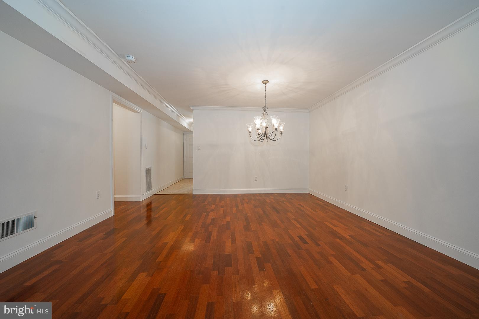 189 Valley Stream Lane Chesterbrook, PA 19087 - Photo 7 of 22 an empty room with wooden floor and chandelier