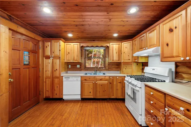a kitchen with stainless steel appliances granite countertop wooden cabinets stove top oven and sink