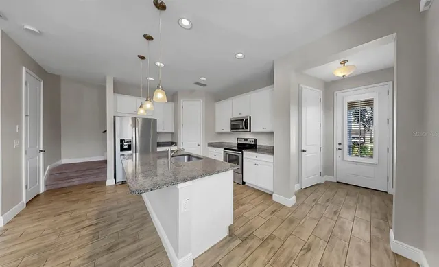 a large kitchen with stainless steel appliances granite countertop a sink dishwasher stove and oven