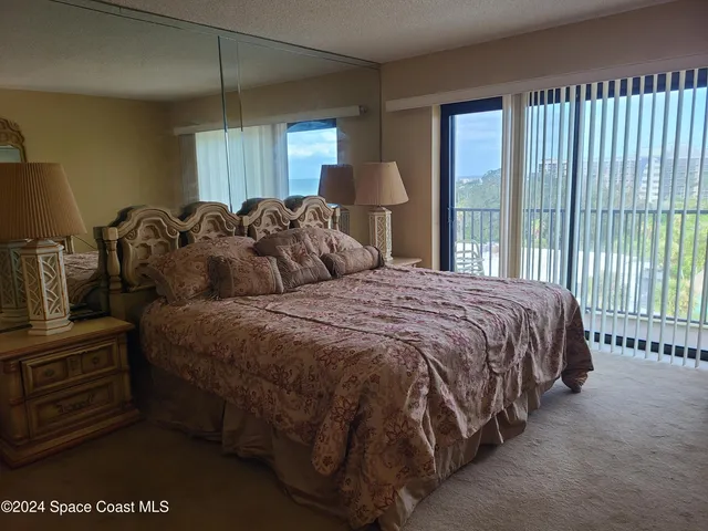 a bedroom with a bed a mirror and lamp