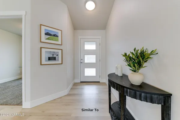 a view of a hallway with wooden floor and a potted plant