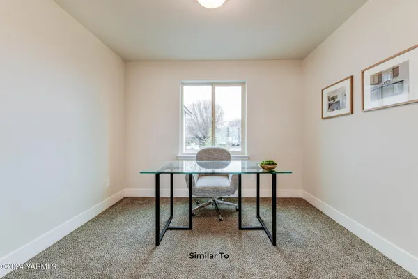 a view of a workspace with furniture and a window