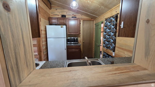 5782 Pineview Loop, Unit 921 Kamas, UT 84036 - Photo 5 of 29 Kitchen featuring a double basin stainless steel sink, granite-style countertops, wood-finish cabinetry, and tongue-and-groove wood paneling on walls and ceiling