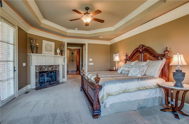 4219 Two Rivers Lane Franklin, TN 37069 - Photo 12 of 20 a bedroom with a bed and a fireplace