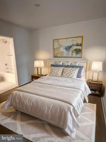 a spacious bedroom with a bed and a painting on the wall