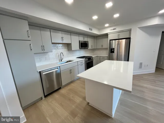 a kitchen with stainless steel appliances a refrigerator sink and microwave