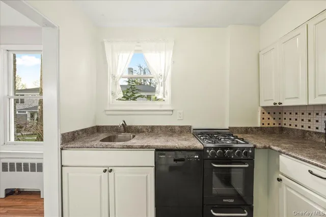 a utility room with granite countertop cabinets washer and dryer
