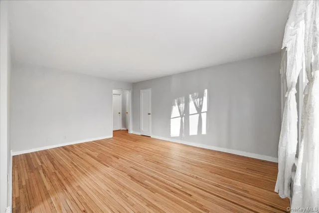 a big room with wooden floor and windows in a room