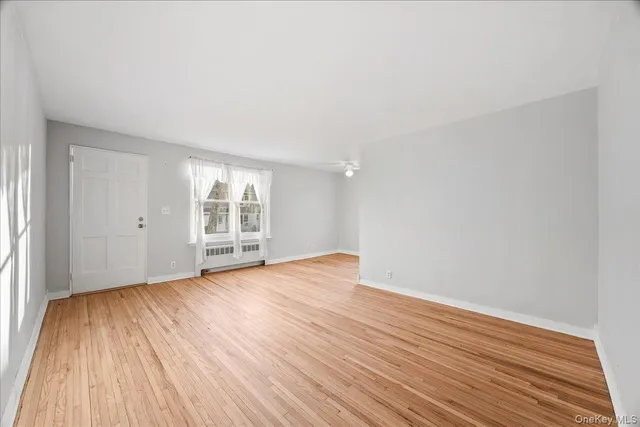 wooden floor in an empty room with a window