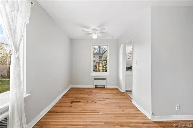 a view of a hallway with wooden floor and a chandelier