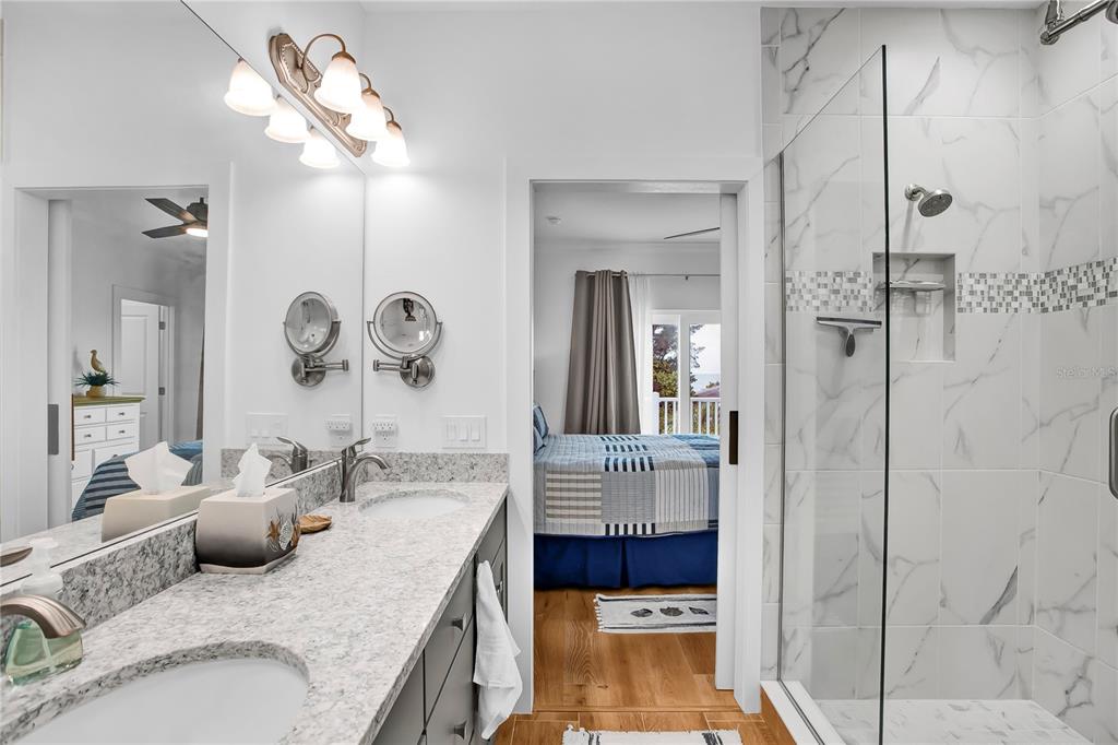 19915 Gulf Boulevard, Unit 204 Indian Rocks Beach, FL 33785 - Photo 27 of 47 a bathroom with a granite countertop sink a mirror and shower