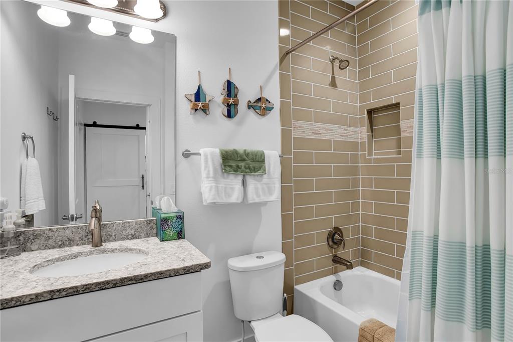 19915 Gulf Boulevard, Unit 204 Indian Rocks Beach, FL 33785 - Photo 32 of 47 a bathroom with a granite countertop sink mirror vanity and toilet