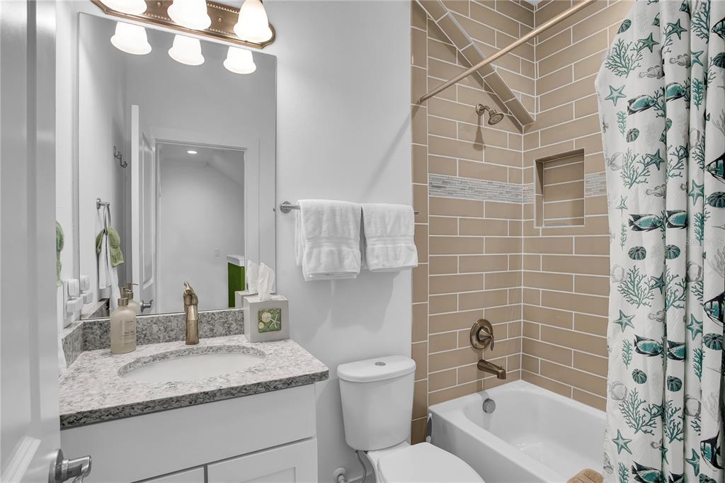 19915 Gulf Boulevard, Unit 204 Indian Rocks Beach, FL 33785 - Photo 39 of 47 a bathroom with a granite countertop sink a toilet and bathtub