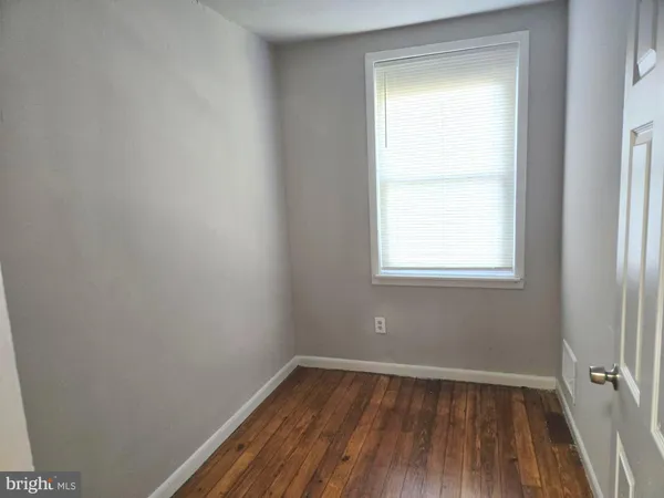 a view of a room with wooden floor and window