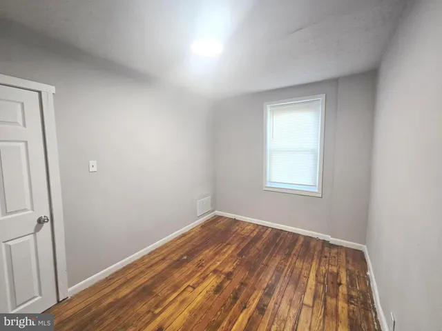 a view of a room with wooden floor and window