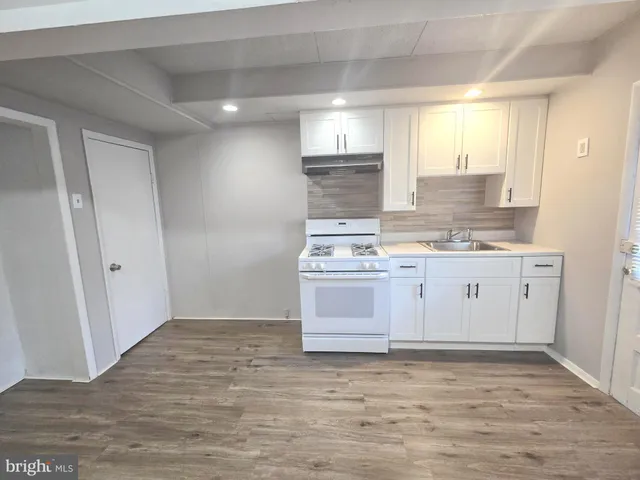 a view white cabinets and wooden floor
