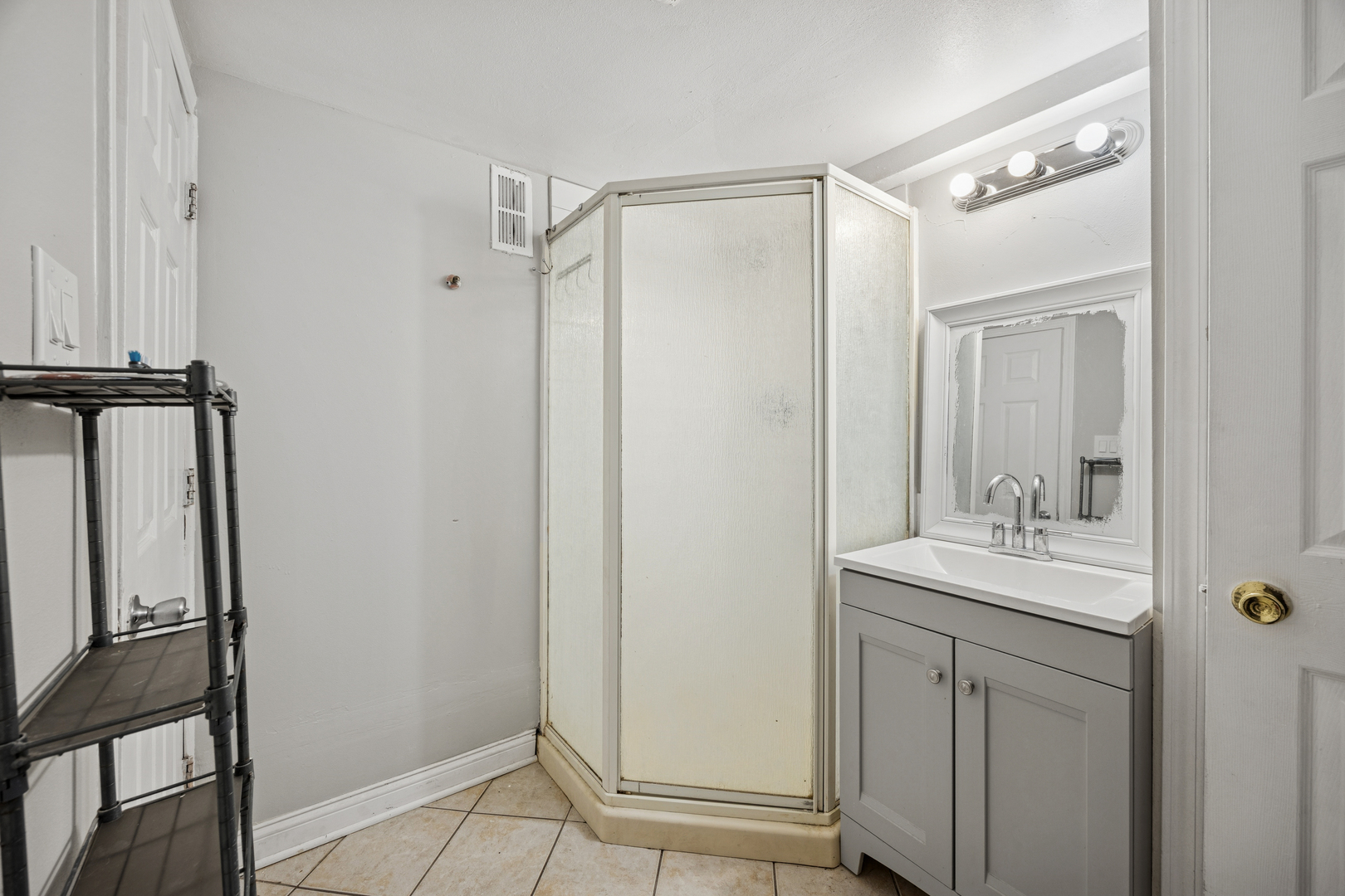 5533 West 63rd Place Chicago, IL 60638 - Photo 15 of 20 a bathroom with a sink a mirror and shower